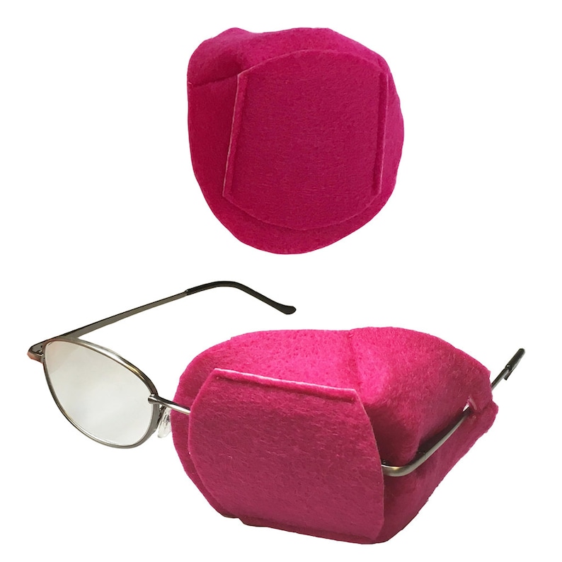 Peut inclure: Deux prot&egrave;ge-lunettes en feutre rose vif. Un protecteur est pr&eacute;sent&eacute; s&eacute;par&eacute;ment, et l'autre est montr&eacute; attach&eacute; &agrave; une paire de lunettes. Les protecteurs ont un rabat rectangulaire sur le devant.