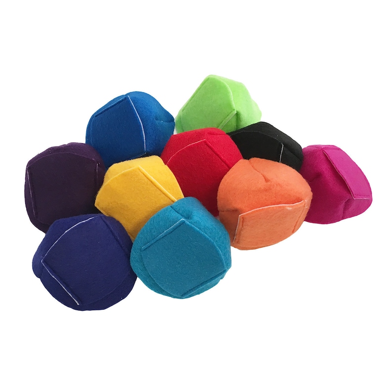Peut inclure: Un ensemble de jouets en feutre en forme de cube, aux couleurs vives, notamment bleu, vert, rouge et orange. Chaque cube est orn&eacute; de coutures blanches et d'un patch carr&eacute;. Les jouets sont empil&eacute;s.