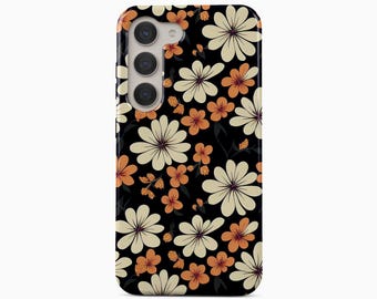 May include: A black smartphone case featuring a repeating pattern of cream and orange flowers with dark centers. The case has a vertical camera cutout on the upper left side containing three circular lenses. The text BOHO Case studio is visible.
