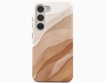 Peut inclure: Une coque de smartphone présentant un motif aquarelle de collines abstraites superposées dans des tons variés de beige, de brun clair et de brun. La coque possède une découpe pour un système de triple objectif et un flash sur le côté supérieur gauche.