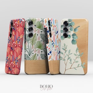 Peut inclure: Quatre coques de téléphone avec des motifs botaniques. Les coques présentent une base en bois et des motifs floraux colorés en rouge, vert et bleu. Une coque a un motif de branche d'eucalyptus. Les coques sont de Boho Case Studio.