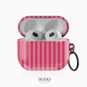 May include: Pink and white striped protective case for AirPods with a small black ring attached to the case.