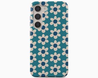 May include: A teal smartphone case featuring a repeating pattern of six-petaled flowers with cream-colored petals and dark blue centers. The case has a cutout for a triple-lens camera system on the upper left side. The text BOHO Case studio is below.