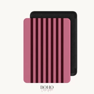 Puede incluir: Una funda rectangular para lector electrónico con un patrón de rayas verticales en tonos alternos de rosa empolvado y burdeos oscuro. La funda tiene un marco negro sólido y un acabado texturizado, con el texto Boho Case Studio impreso abajo.