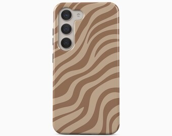 Peut inclure: Une coque de téléphone portable présentant un motif abstrait ondulé composé de rayures alternées beige clair et marron moyen. La coque comporte une découpe pour un système de triple objectif et un flash. Le texte BOHO Case studio est visible.