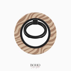 May include: A round phone grip with a black ring and a brown and beige zebra stripe pattern. The text "BOHO Case Studio" is printed below the ring.