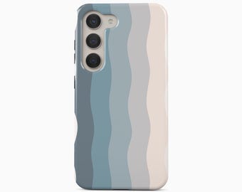 Peut inclure: Une coque de smartphone avec un motif ondulé vertical dans des tons bleu ardoise, bleu clair, gris et crème. La coque présente une découpe pour un système de triple objectif photo et un flash sur le côté supérieur gauche. Le texte BOHO Case studio est visible.