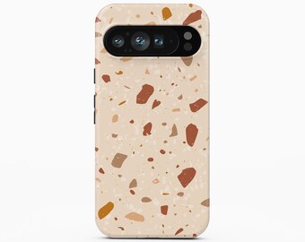May include: A smartphone case featuring a light beige background with a scattered terrazzo pattern of brown, terracotta, and mustard yellow flecks. The case has a black horizontal camera cutout at the top and the text BOHO Case studio at the bottom.