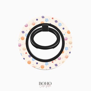 May include: A white phone ring holder with a black ring and a pattern of colorful planets and stars.