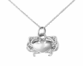 May include: A silver crab pendant necklace with a delicate chain. The crab is detailed with claws and legs.
