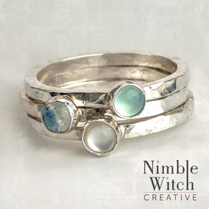 Three stacking rings each bezel set with a 4mm natural birthstones. Rings are made of hammered, 14 gauge, square, sterling silver. In this set is a Mother of Pearl, a Moonstone and an Aqua Chalcedony.