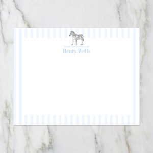 Puede incluir: Papelería blanca con un borde a rayas azul claro y el texto "from the nursery of Henry Wells". Una pequeña ilustración de una cebra está en la parte superior. La papelería está sobre una superficie de mármol.