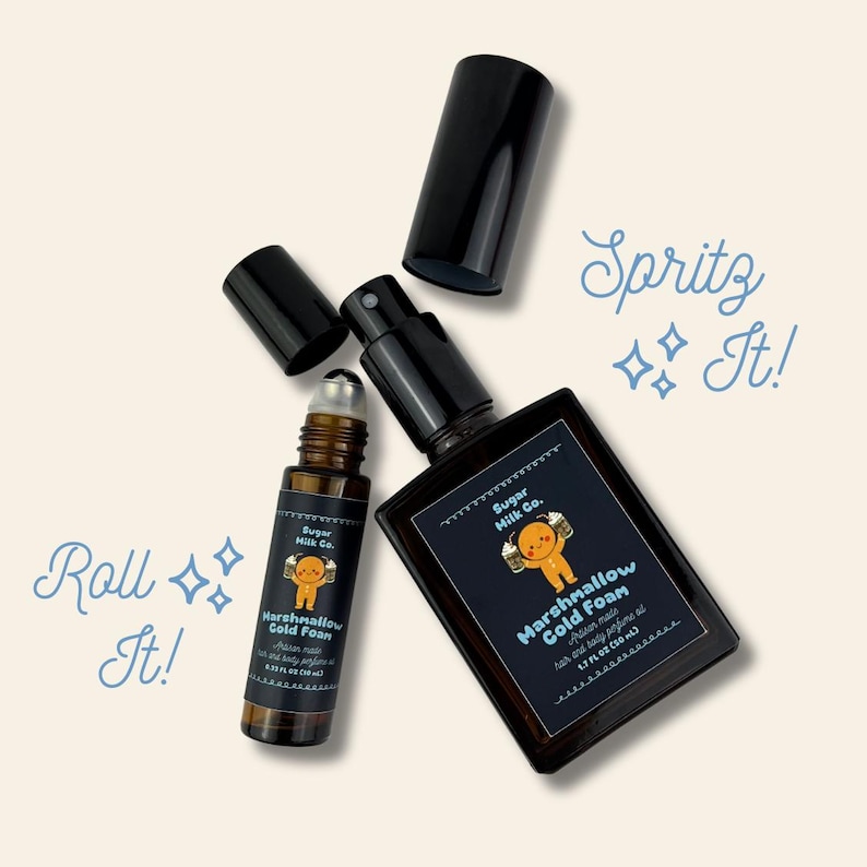 May include: Two perfume bottles, one roll-on and one spray, with black caps and labels. The labels read "Marshmallow Cold Foam" and feature a gingerbread man graphic. The spray bottle contains 50 ml.