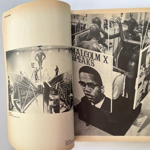 K&ouml;nnte beinhalten: Offenes Buch mit Schwarz-Wei&szlig;-Bildern. Eine Seite zeigt eine b&uuml;hnenartige Struktur mit Figuren. Die andere Seite zeigt ein Portr&auml;t von Malcolm X mit dem Text "Malcolm X Speaks" und andere Bilder.