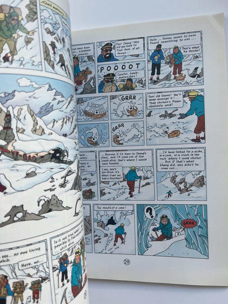 May include: Open book with comic strip panels depicting a snowy mountain scene. Characters in winter attire are shown interacting with each other and the environment. Text bubbles contain dialogue and sound effects like "GRRR".