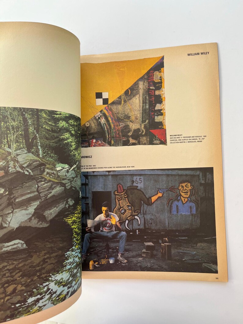 K&ouml;nnte beinhalten: Offenes Buch mit einer Seite mit einem farbenfrohen abstrakten Gem&auml;lde mit einem schwarz-wei&szlig;en Quadrat. Die gegen&uuml;berliegende Seite zeigt eine Fotografie eines Waldes. Das Buch liegt auf einer wei&szlig;en Oberfl&auml;che.