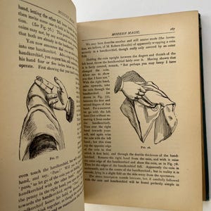 K&ouml;nnte beinhalten: Offene Buchseiten mit Illustrationen und Text aus "Modern Magic". Die Illustrationen zeigen Handgesten und M&uuml;nztricks. Der Text beschreibt, wie man Zaubertricks mit M&uuml;nzen und Taschent&uuml;chern vorf&uuml;hrt.