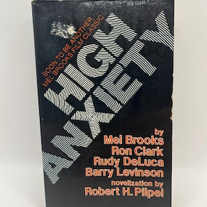 May include: A vintage paperback book with a black cover featuring the title "HIGH ANXIETY" in white, stylized text. The cover also includes the names of Mel Brooks, Ron Clark, and others, with the text "SOON TO BE ANOTHER MEL BROOKS FILM CLASSIC".