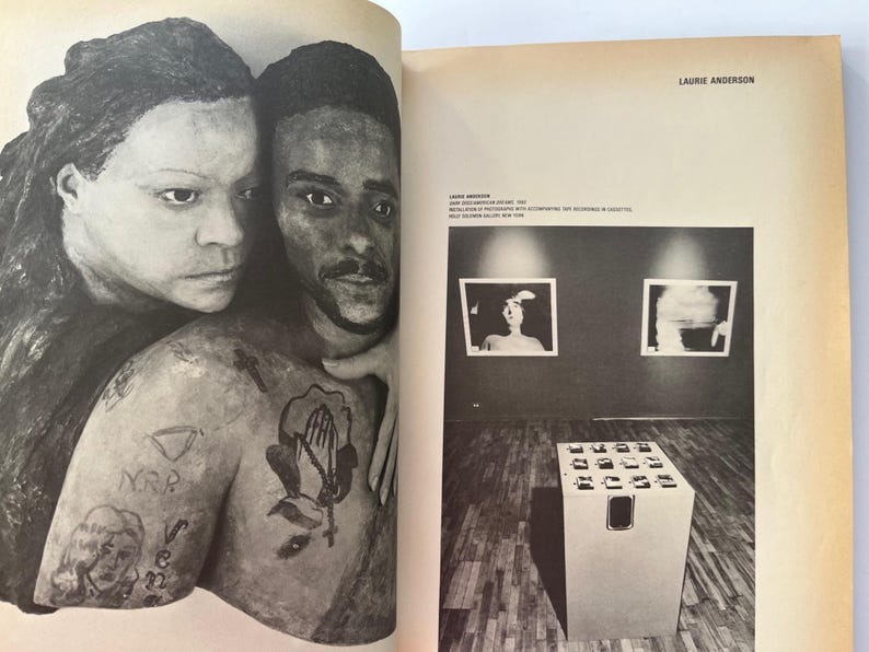 K&ouml;nnte beinhalten: Schwarz-Wei&szlig;-Kunstwerk von zwei Personen, von denen eine die andere umarmt. Die umarmte Person hat T&auml;towierungen auf Arm und Brust. Das Bild stammt aus einem Buch mit Text auf der rechten Seite. Der Text lautet "Laurie Anderson".