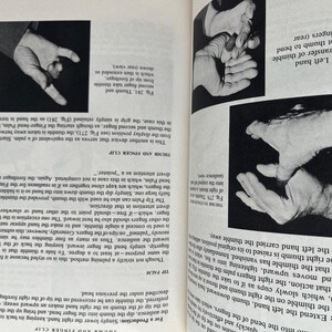 May include: Black and white images from a book on stage magic. The images show hands performing various sleight-of-hand techniques, including the thumb and finger clip and the tip palm. Text accompanies the illustrations.