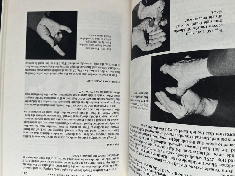 May include: Black and white images from a book on stage magic. The images show hands performing various sleight-of-hand techniques, including the thumb and finger clip and the tip palm. Text accompanies the illustrations.