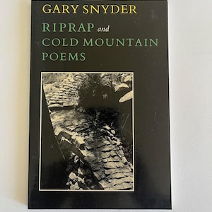 May include: A black book cover with the title "Riprap and Cold Mountain Poems" by Gary Snyder. The cover features a black and white photograph of a stone path.