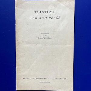 Könnte beinhalten: Ein Vintage-Broschüre mit dem Titel "TOLSTOYS KRIEG UND FRIEDEN" mit dem Text "Einführung in die Sendereihe". Das Cover ist cremefarben mit schwarzem Text. Der untere Teil der Broschüre lautet "THE BRITISH BROADCASTING CORPORATION" und "PRICE SIXPENCE."