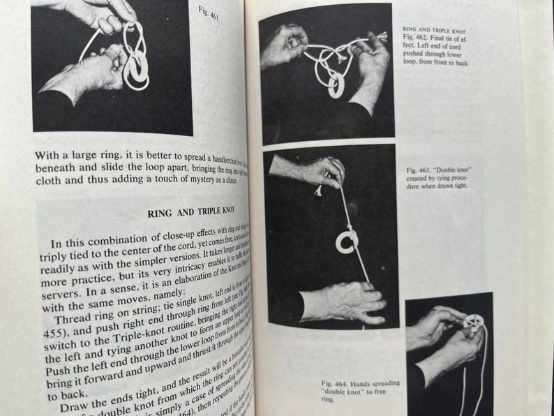 May include: Black and white images from a book on magic tricks. The illustrations show hands manipulating rope and rings to create knots. Text explains the steps for the ring and triple knot.