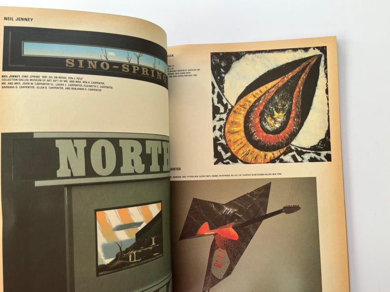 K&ouml;nnte beinhalten: Offenes Buch mit Kunstdrucken. Ein Druck zeigt eine Landschaft mit dem Text "SINO-SPRING". Ein weiterer Druck ist ein abstraktes Design mit orange, roten und schwarzen Farben. Ein dritter Druck ist ein gitarrenf&ouml;rmiges Design.