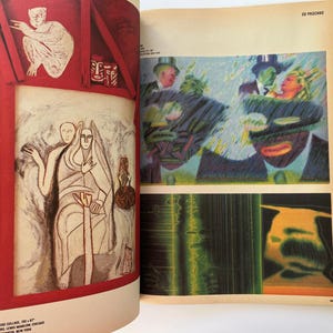 K&ouml;nnte beinhalten: Eine Magazinseite mit Kunstwerken. Ein Bild zeigt ein Gem&auml;lde von zwei Figuren in Wei&szlig;- und Beiget&ouml;nen. Das andere Bild zeigt ein farbenfrohes Gem&auml;lde mit Figuren in Anz&uuml;gen und H&uuml;ten. Die Seite hat Text.