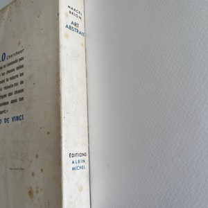 Pode incluir: Uma capa de livro branca com texto azul que l&ecirc; "Marcel Brion Art Abstrait" e "Editions Albin Michel".