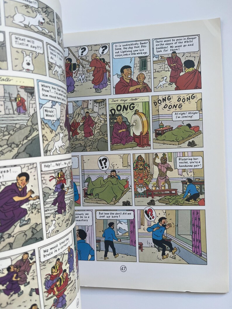 May include: A comic book page featuring panels with illustrations and speech bubbles. The panels depict scenes with characters in robes, a dog, and text. The page includes the number 47.