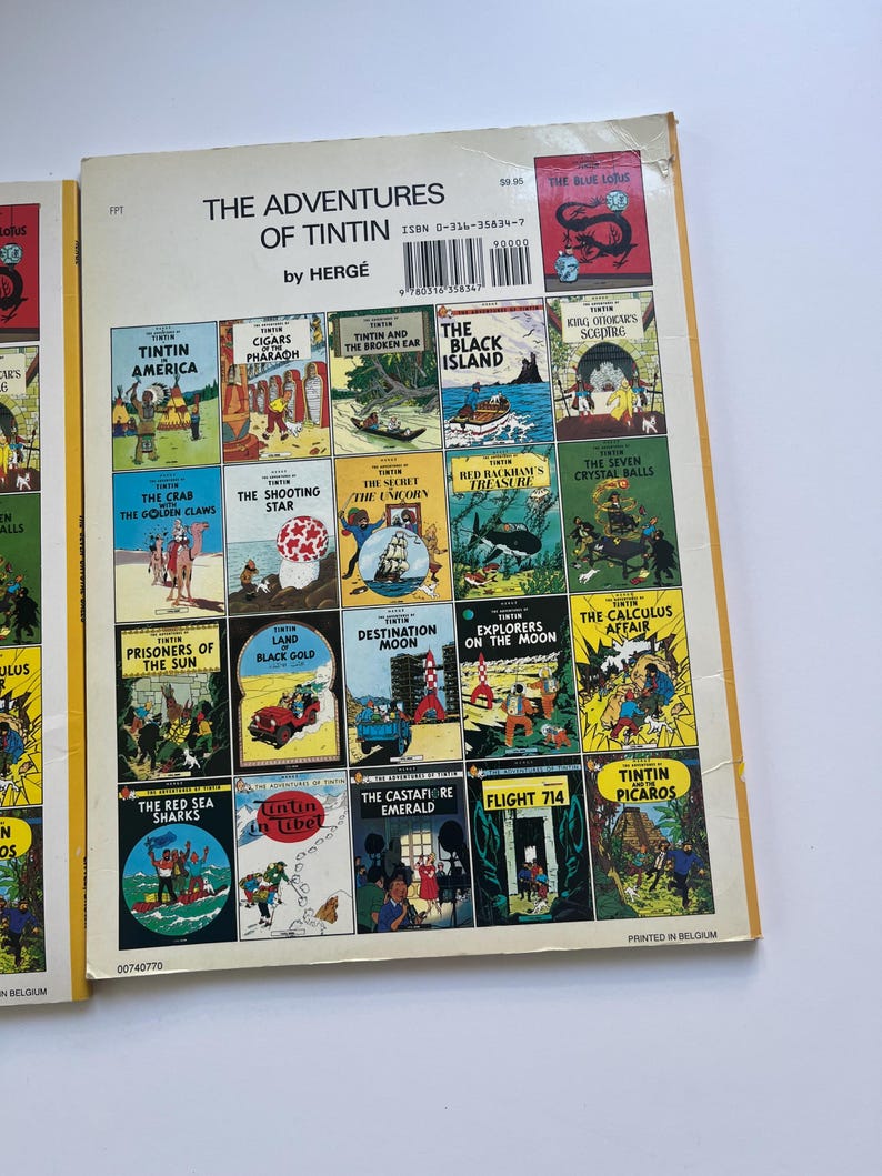 May include: A collection of Tintin comic books featuring various adventures, including "Tintin in America" and "The Black Island." The covers display colorful illustrations and the title "The Adventures of Tintin" by Herg&eacute;.