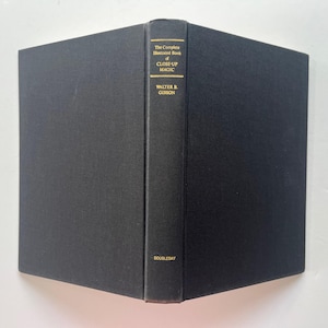 May include: A hardcover book titled "The Complete Illustrated Book of Close-Up Magic" by Walter B. Gibson. The book has a black cover and spine with gold lettering. The publisher's name, Doubleday, is printed at the bottom of the spine.