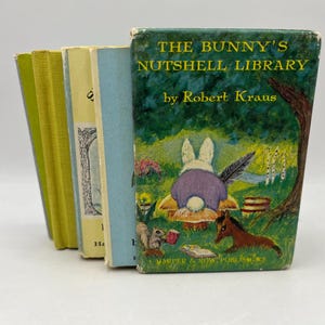 May include: A collection of vintage children's books, including "The Bunny's Nutshell Library" by Robert Kraus. The cover features a whimsical illustration of a bunny, a horse, and a squirrel in a forest setting. The books have colorful spines.