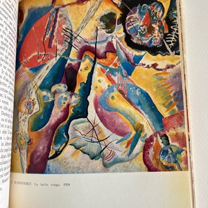 Pode incluir: Uma pintura abstrata com um esquema de cores vermelho, amarelo, azul e roxo. A pintura &eacute; intitulada "La tache rouge" e &eacute; datada de 1914. O nome do artista, "KANDINSKY", est&aacute; impresso abaixo do t&iacute;tulo.