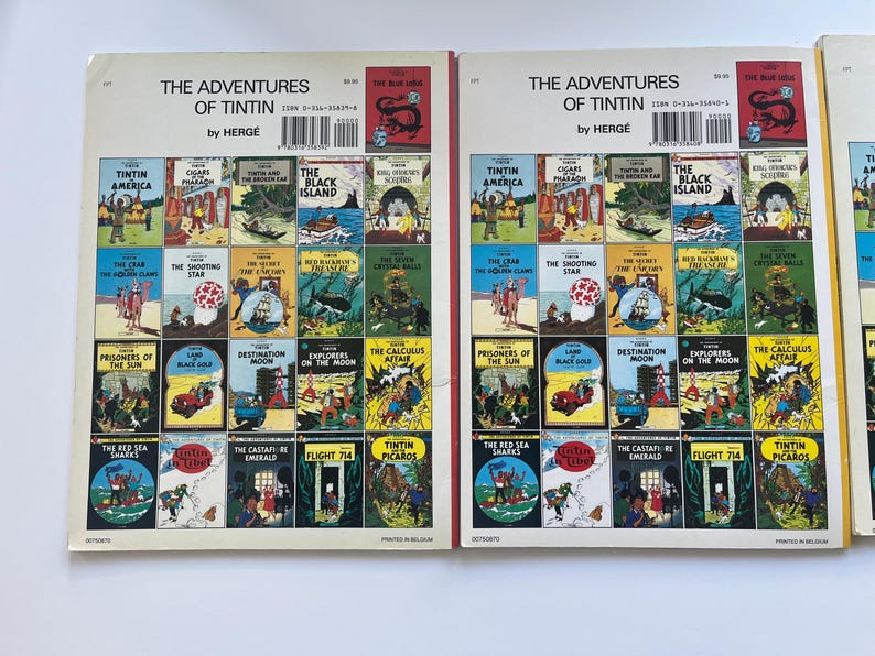 May include: A collection of vintage "The Adventures of Tintin" comic books by Herg&eacute;. The covers feature colorful illustrations and titles like "Tintin in America," "The Black Island," and "Destination Moon."