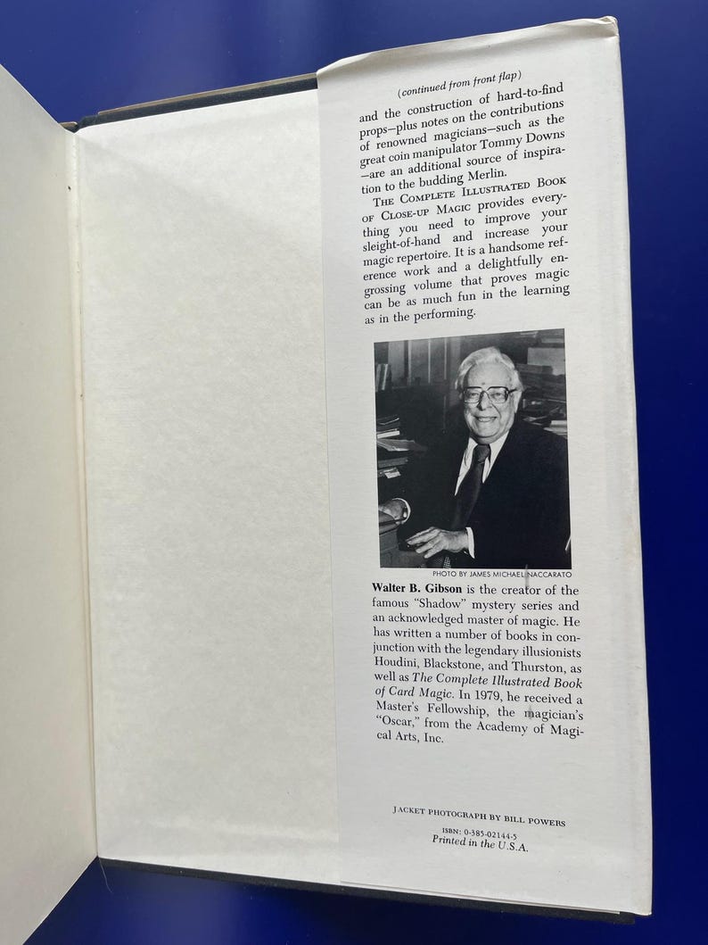 May include: Open book with text and a black and white photo of a man in a suit. The text includes the title "The Complete Illustrated Book of Close-Up Magic" and the author's name, Walter B. Gibson.