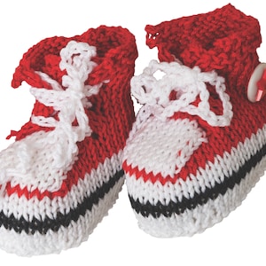 May include: A pair of red, white, and black knitted baby booties with a button on one bootie. The booties have a white lace and a black stripe around the bottom.