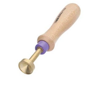 May include: A wooden handled tool with a purple plastic grip and a brass tip. The tip is round and has a pointed end.