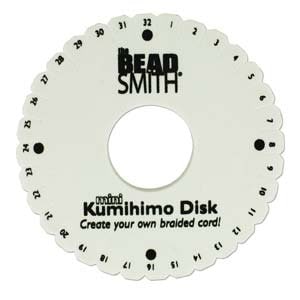 May include: White plastic Kumihimo Disk with black text and markings. The text reads "confund Kumihimo Disk Create your own braided cord!" and the numbers 1 through 32 are printed around the edge.