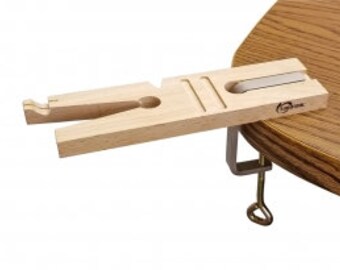 May include: A wooden clamp-on ring mandrel for jewelry making. The mandrel is made of light wood and has a clamp that attaches to a table or workbench.