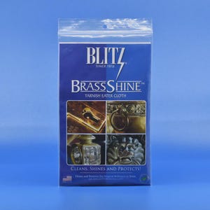 May include: A package of Blitz Brass Shine tarnish eater cloth. The blue package features the brand name and product information, along with images of brass items. The text reads "Cleans, Shines and Protects!" and "Cleans and Restores the Original Brilliance to Brass."