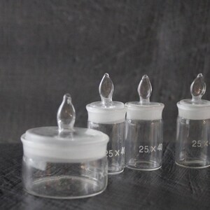 May include: Four clear glass bottles with glass stoppers. The bottles are labelled with the dimensions "25 x 40".