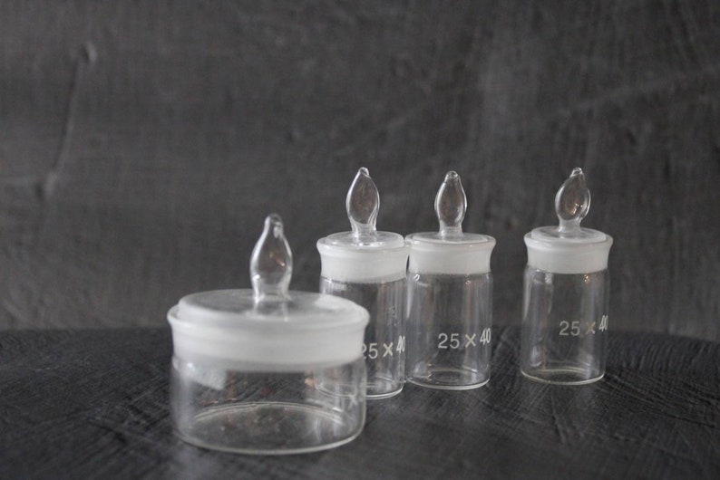 May include: Four clear glass bottles with glass stoppers. The bottles are labelled with the dimensions "25 x 40".