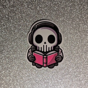 May include: A cartoon sticker of a skull wearing headphones and reading a pink book.