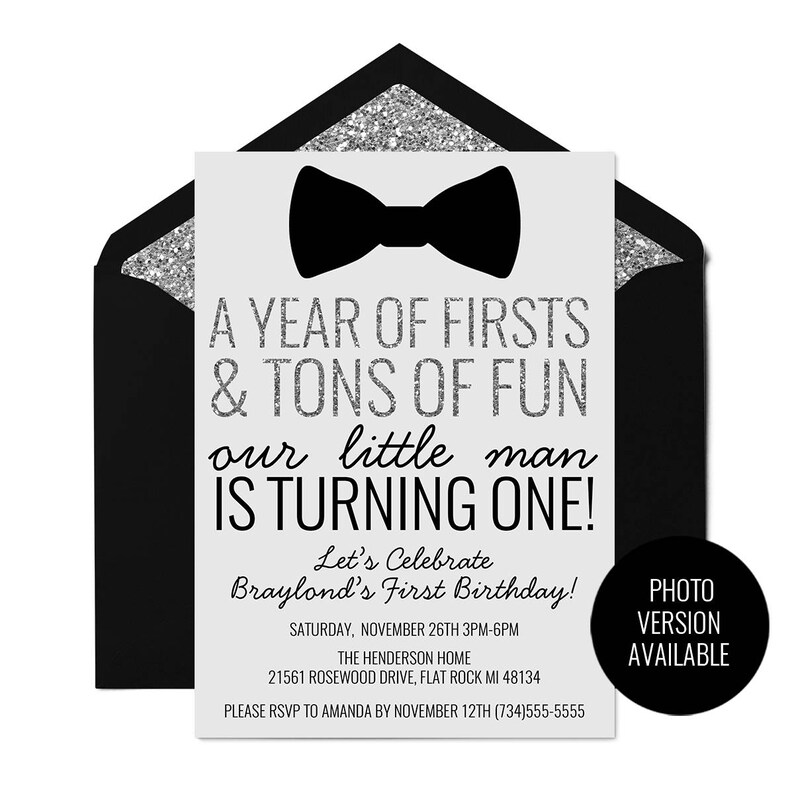 May include: A black and white invitation with silver glitter accents. The invitation features a black bow tie and the text "A Year of Firsts & Tons of Fun our little man is turning one! Let's Celebrate Braylond's First Birthday! Saturday, November 26th 3PM-6PM The Henderson Home 21561 Rosewood Drive, Flat Rock MI 48134 Please RSVP to Amanda by November 12th (734)555-5555 Photo Version Available"