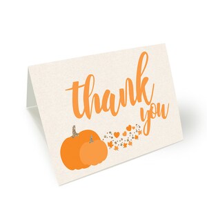 May include: Orange thank you card with a pumpkin design and gold glitter accents. The card says "thank you" in a handwritten font.