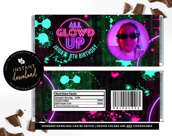 Puede incluir: Un envoltorio de barra de chocolate de color rosa y verde neón que brilla en la oscuridad con el texto "All Glow'd Up" y "Jaida's 8th Birthday". El envoltorio tiene una foto de un niño con gafas de sol y una camiseta rosa. El envoltorio también tiene una etiqueta de información nutricional con el texto "Good Vibes" y "Birthday Fun".