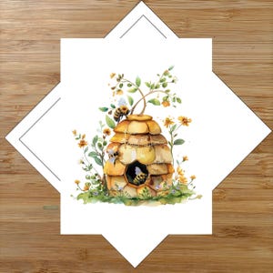 May include: A square greeting card featuring a watercolor illustration of a golden beehive surrounded by yellow wildflowers and green foliage. Three bees are depicted, with one entering the hive entrance and two perched on the structure.
